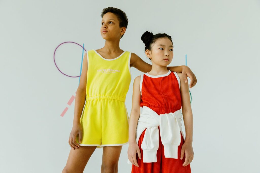 Studio portrait of trendy teenagers in colorful sportswear standing with a confident pose.
